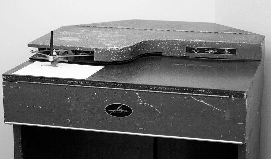 Máquina de assinatura Autopen, modelo institucional em gabinete metálico, com braço articulado e folha posicionada sob a caneta